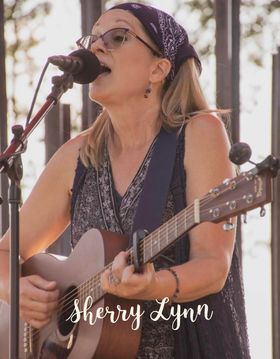 Photo of Sherry Lynn playing guitar and singing into a microphone
