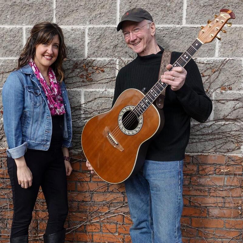 Photo of Wanda and Charlie posing together with a guitar