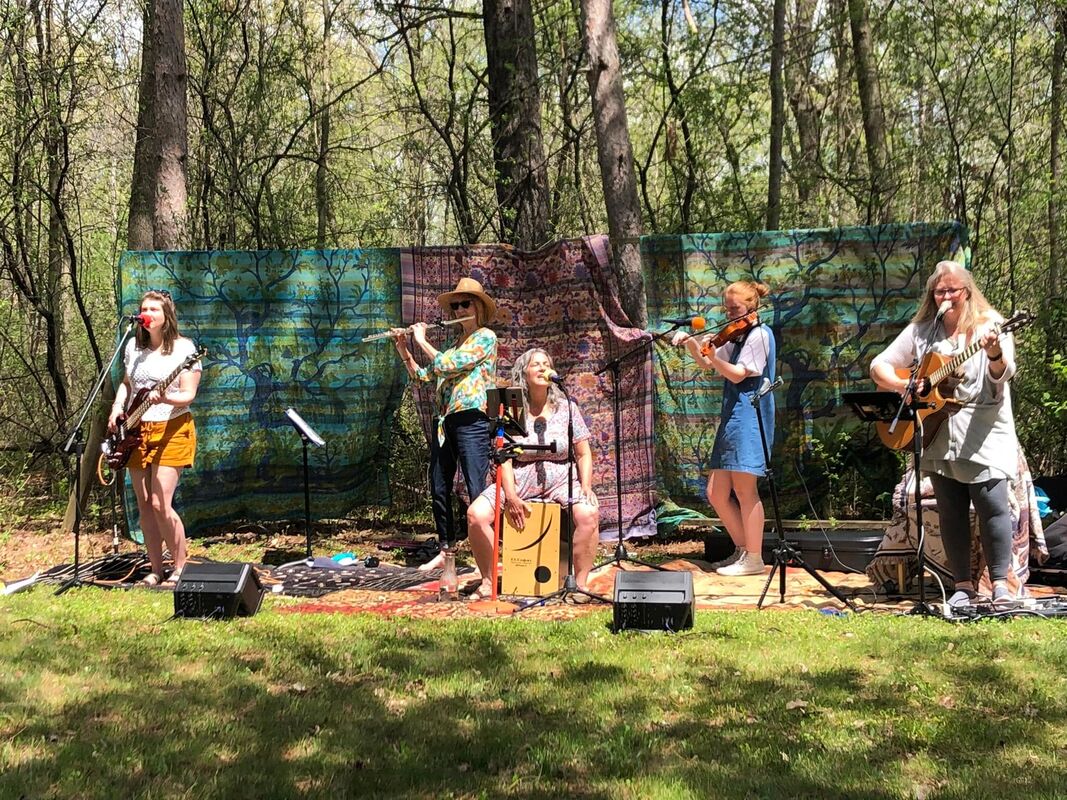 Photo of the five band members of Girl Band performing music outdoors